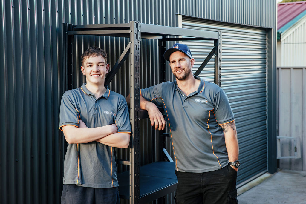 Ben and Dylan at shelving and storage ne standing against a shelve